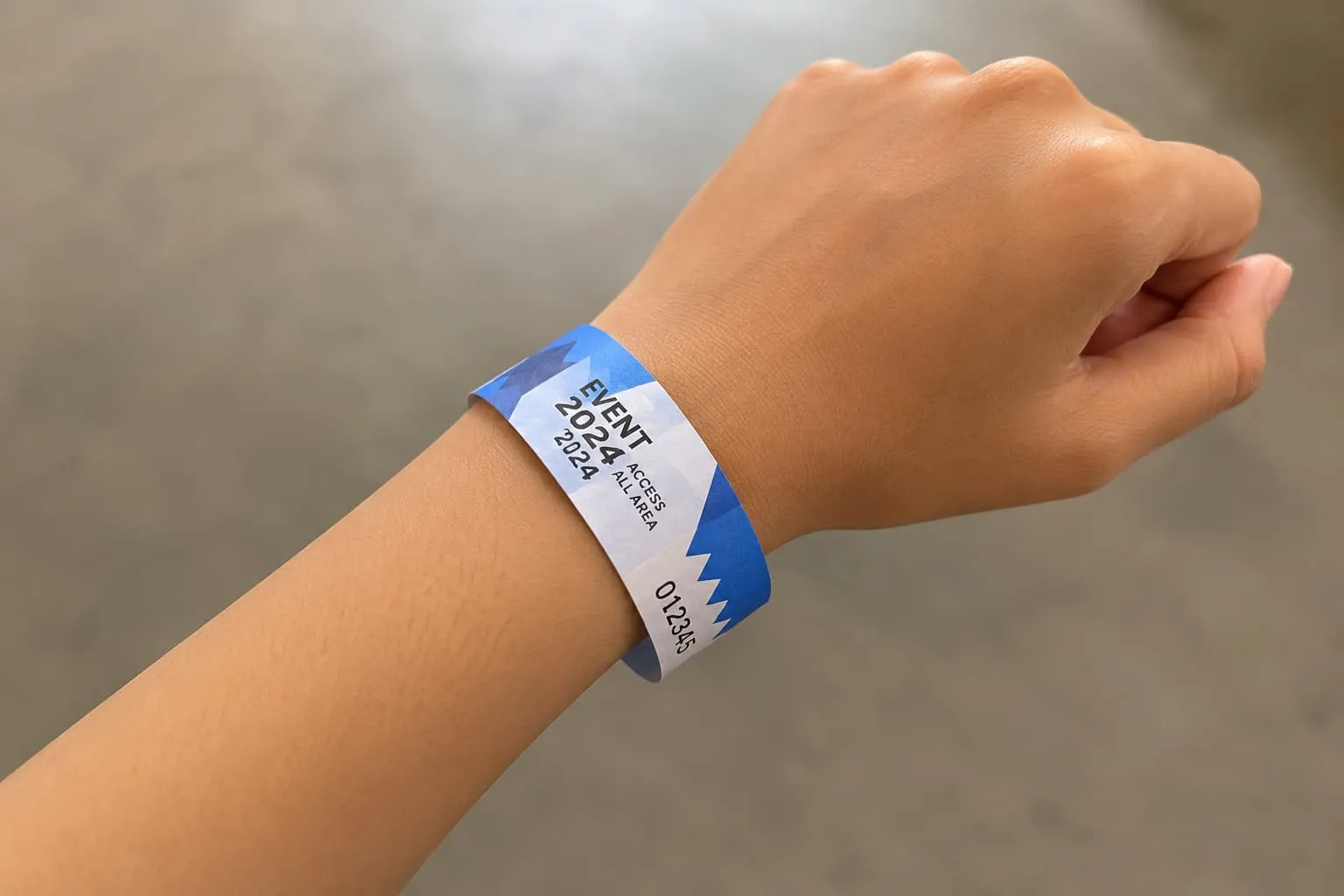 Tangan memakai gelang tiket kertas custom untuk event | idgrafis